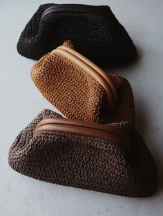 three brown and black purses sitting next to each other on a white table top