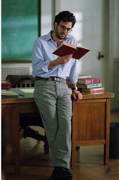 a man sitting on a desk reading a book