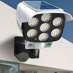 a solar powered security camera mounted on the side of a building