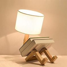 a lamp that is sitting on top of a wooden stand with a book in it