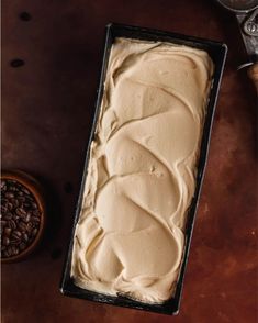 a cake in a pan sitting on top of a table next to some coffee beans