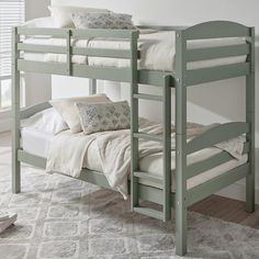 a green bunk bed with white sheets and pillows