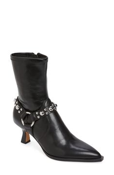 Polished studs highlight the harness strap of a moto-chic bootie complete with a pointy toe. 2 1/4" heel (size 8.5) 7" shaft Side zip closure Synthetic and leather upper/textile, synthetic and leather lining/synthetic sole Imported Fitted Studded Boots With Pointed Toe, Edgy Ankle-high Studded Moto Boots, Edgy Ankle Strap Boots, Edgy Fitted Boots With Ankle Strap, Edgy Fitted Ankle Strap Boots, Edgy Boots With Rivets For Night Out, Edgy Studded Moto Boots With Pointed Toe, Edgy Studded High Heel Boots, Punk Heeled Boots With Studs For Fall