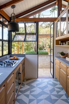 a kitchen with tiled flooring and wooden cabinets in the center, along with an outdoor shower