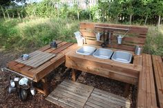 an outdoor kitchen made out of wooden pallets with sink and counter tops on the side