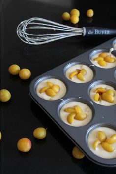 an image of cupcakes with icing in the middle on a tray and whisks next to it