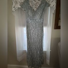 a dress hanging on a curtain in front of a window