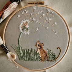 the embroidery is being worked on with thread and needles, along with some other crafting supplies