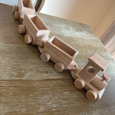 a wooden toy train sitting on top of a table next to a mirror and window