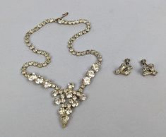 For sale is a beautiful vintage rhinestone jewelry set, that was handed down from an Aunt, which is why we think this set may have been purchased in the 1940s rather than the 1950s, but it's hard to know for sure. The necklace is a choker or collar or bib type design, and the screw back earrings appear to match the necklace. We cannot be sure the necklace and earrings are not a marriage, rather than an original set, but the color, cut and age of the rhinestones all appear to be consistent. 1940s Necklace, 50s Jewelry, 1940s Jewelry, Rhinestone Jewelry Set, Vintage Rhinestone Jewelry, Bib Collar, Basic Design, Necklace And Earring Set, Etsy Favorites