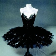 a mannequin wearing a black dress on display