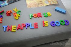 there is a cake with letters and magnets on it that says for us the apple is good