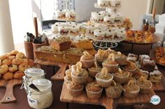 a table topped with lots of cupcakes and muffins