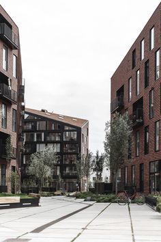 an empty parking lot in front of some brick buildings with bicycles parked on the sidewalk