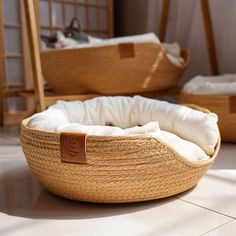 a cat sleeping in a bed on the floor next to another cat laying down behind it