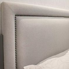 an upholstered headboard with beaded trim on the sides and buttons at the bottom