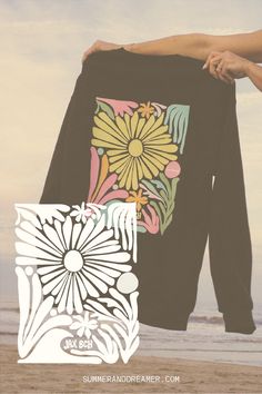 a woman holding onto a black shirt with flowers on it and the words summer sundreamer com