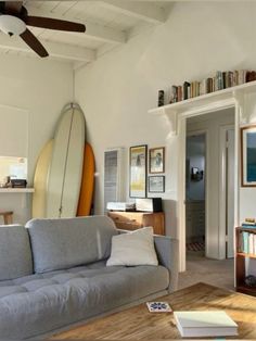 a living room filled with furniture and a surfboard