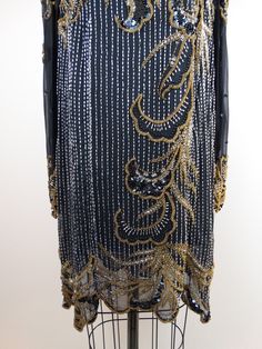 "This is an amazing vintage piece! It's fully embellished with gold and silver beading, sequins and crystal rhinestones in an avant garde art deco design. SO STUNNING! It's in excellent condition! Measurements: Bust - 46\" Waist - 46\" Hips - 46\" Shoulders - 16\" Sleeves - 24\" Length - 33\" Tag Size - 14 This item comes from a pet-free and smoke-free home. If you would like more info or have any questions, please don't hesitate to ask!" Party Season Gatsby Style Embellished Sequin Dress, Opulent Embellished Party Dresses, Gold Sequined Flapper Dress For Party Season, Embellished Flapper Dress For Wedding Festivities, Gold Embellished Sequin Fabric For Formal Wear, Festive Embellished Flapper Dress For Wedding, Gold Sequin Fabric For Evening, Embellished Flapper Dress For Wedding And Festive Events, Embellished Flapper Dress For Wedding And Festive Season