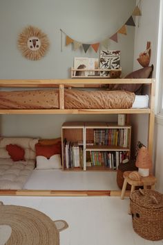 there is a bunk bed in the room with bookshelves and toys on the floor