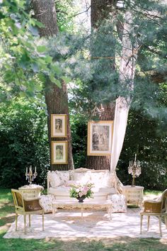 an outdoor seating area with chairs, couches and pictures on the wall above it