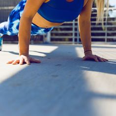 a woman is doing push ups on her hands and knees while wearing blue sports clothing