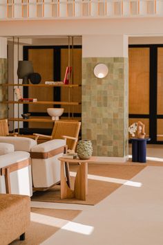 a living room filled with lots of furniture next to a tall wooden shelf on the wall