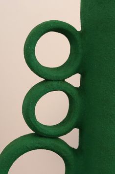 a green sculpture with three circles on it