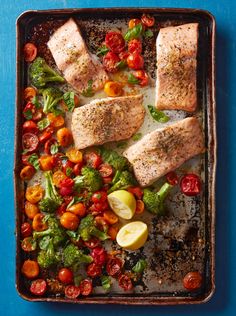 salmon with tomatoes, broccoli and cherry tomatoes on a baking sheet in a pan