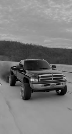 a black and white photo of a truck on the road