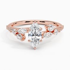 a rose gold engagement ring with an oval cut diamond in the center and side stones