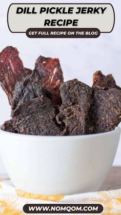 a bowl filled with beef pieces on top of a table