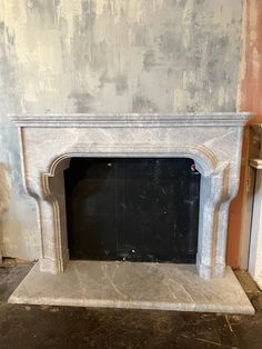 an empty fireplace in a room with no one around it and some paint on the walls