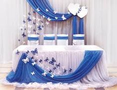 a blue and white wedding table with butterfly decorations