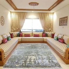 a living room filled with lots of furniture next to a large rug in front of a window