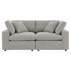 a grey couch with pillows on it and two arms in the same direction, facing each other