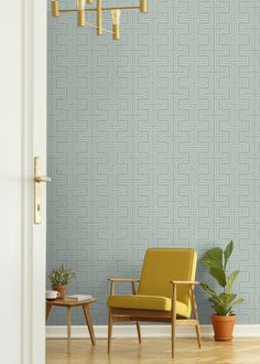 a yellow chair sitting in front of a blue wall next to a potted plant