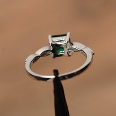 It is a lab emerald ring, princess cut, measures 6mm*6mm, weight about 0.93 cts. The basic metal is sterling silver and plated with rhodium. To change the metal to a solid gold (white/rose) or platinum is also available, please ask for a quotation if you want. You can also go to my shop Home for more elegant rings: https://www.etsy.com/shop/godjewelry?ref=hdr_shop_menu emerald is May birthstone More emerald rings: https://www.etsy.com/shop/godjewelry?ref=seller-platform-mcnav&section_id=2070 Princess Cut Emerald Jewelry, May Birthstone Jewelry With Prong Setting In Princess Cut, Promise Princess Cut Emerald Ring With Center Stone, Princess Cut Emerald Jewelry In White Gold, Princess Cut Emerald Promise Ring With Center Stone, White Gold Princess Cut Emerald Jewelry, Promise Jewelry Princess Cut Emerald, Emerald Solitaire Princess Cut Jewelry, Silver Asscher Cut Emerald Jewelry