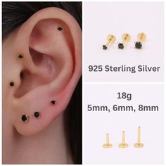 three different types of ear piercings with black stones on each side and gold posts