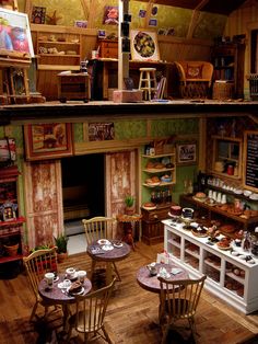 a room filled with tables and chairs next to a fire place in the middle of a kitchen