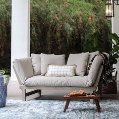 a couch sitting on top of a blue and white rug next to a lamp post