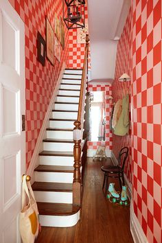 the stairs are lined with red and white checkered wallpaper in this entryway