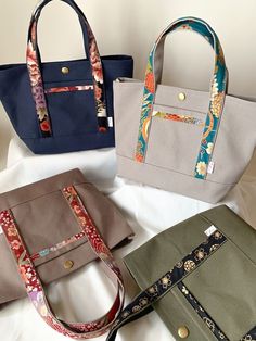 four purses lined up on top of each other in different colors and patterns,