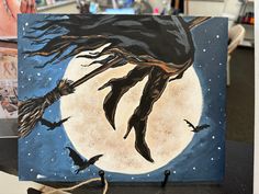 an acrylic painting of a witch flying on her broom