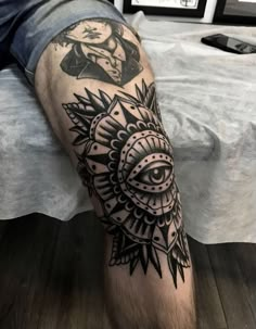 a man's leg with an all seeing eye tattoo on his left arm and chest