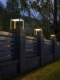 three lights are on the side of a fence