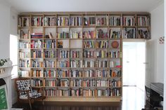 a book shelf filled with lots of books next to a fire place in a living room