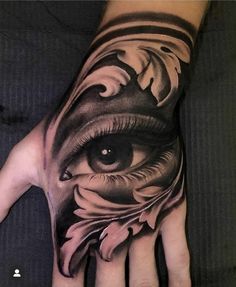 a person's hand with an eye and flower tattoo on the left palm,