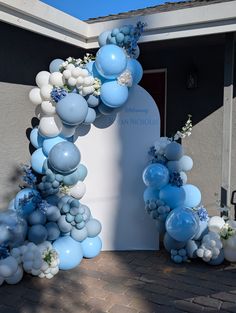 blue and white balloons are attached to the arch