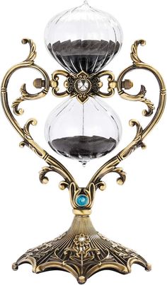 an ornate gold and glass hourpiece with blue stone in the center, on a white background